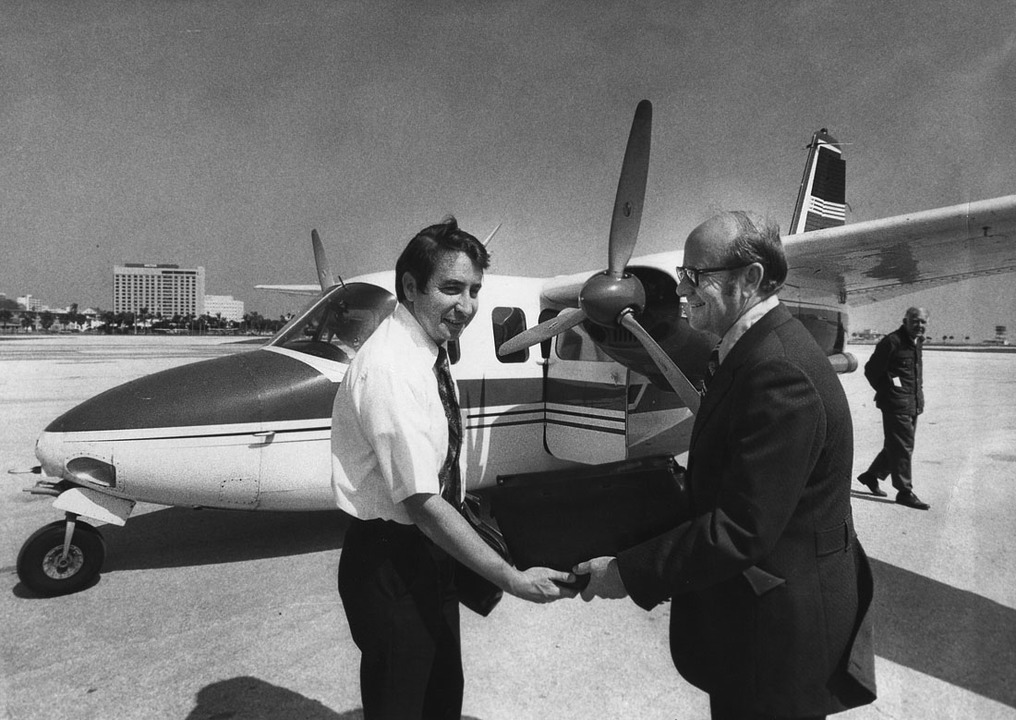Sun Airlines started regular passenger service to Albert Whitted airport in downtown St. Petersburg in February 1973. Robert Gray (left), pilot and sales director for Sun Airlines welcomes passenger Irwin Miller in front of an Aero Commander used on the flights.