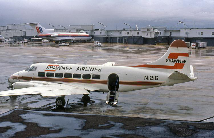 Shawnee Airlines Heron N121G is pictured on a rainy day at Miami in September 1978.