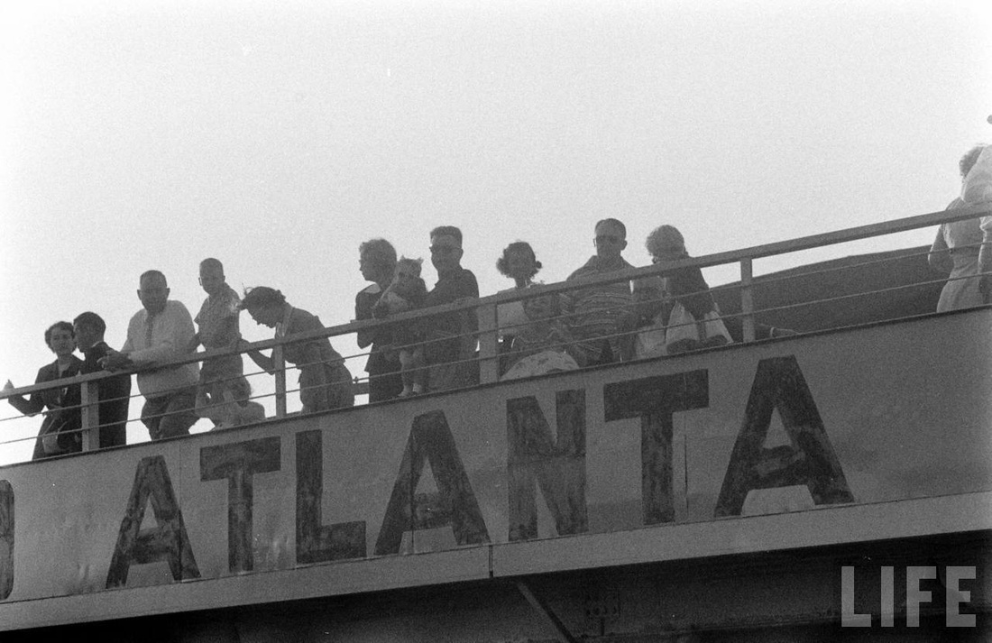 People enjoying the view from the Atlanta airport observation deck on a hazy summer day in 1956.