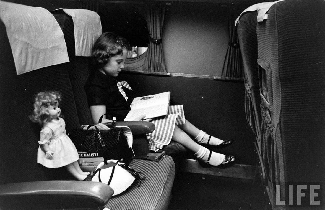 A girl and her doll wait to depart Atlanta aboard an Eastern Air Lines evening flight.