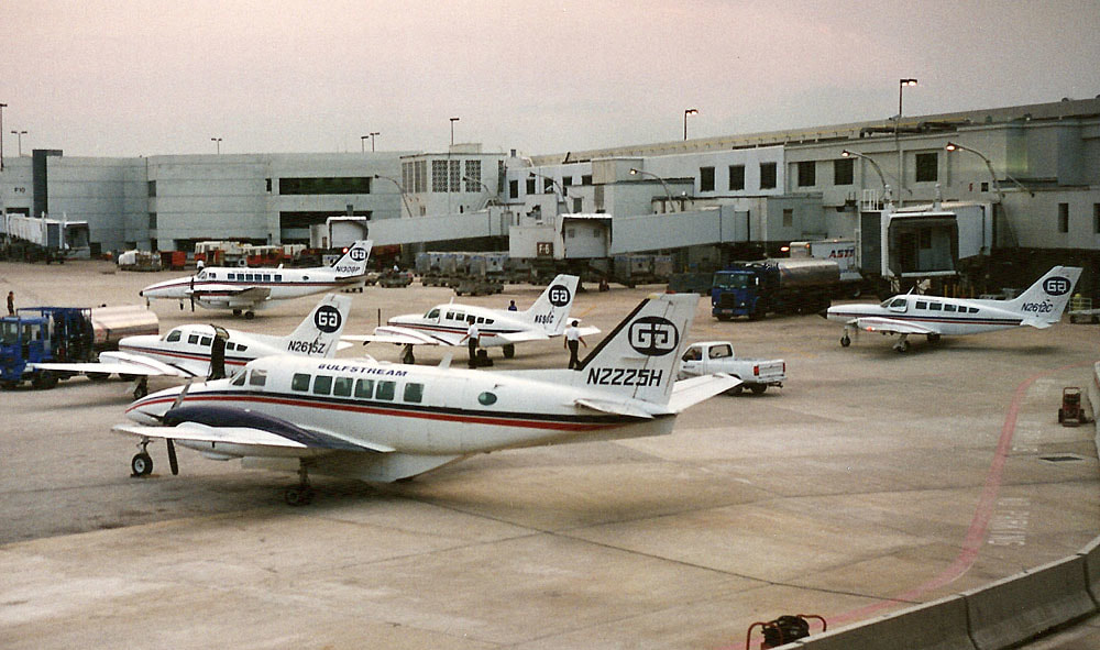 Three Cessna 402s and two Beech 99s sit on the crowded Gulfstream International ramp on a cloudy day in Miami, June 1995.